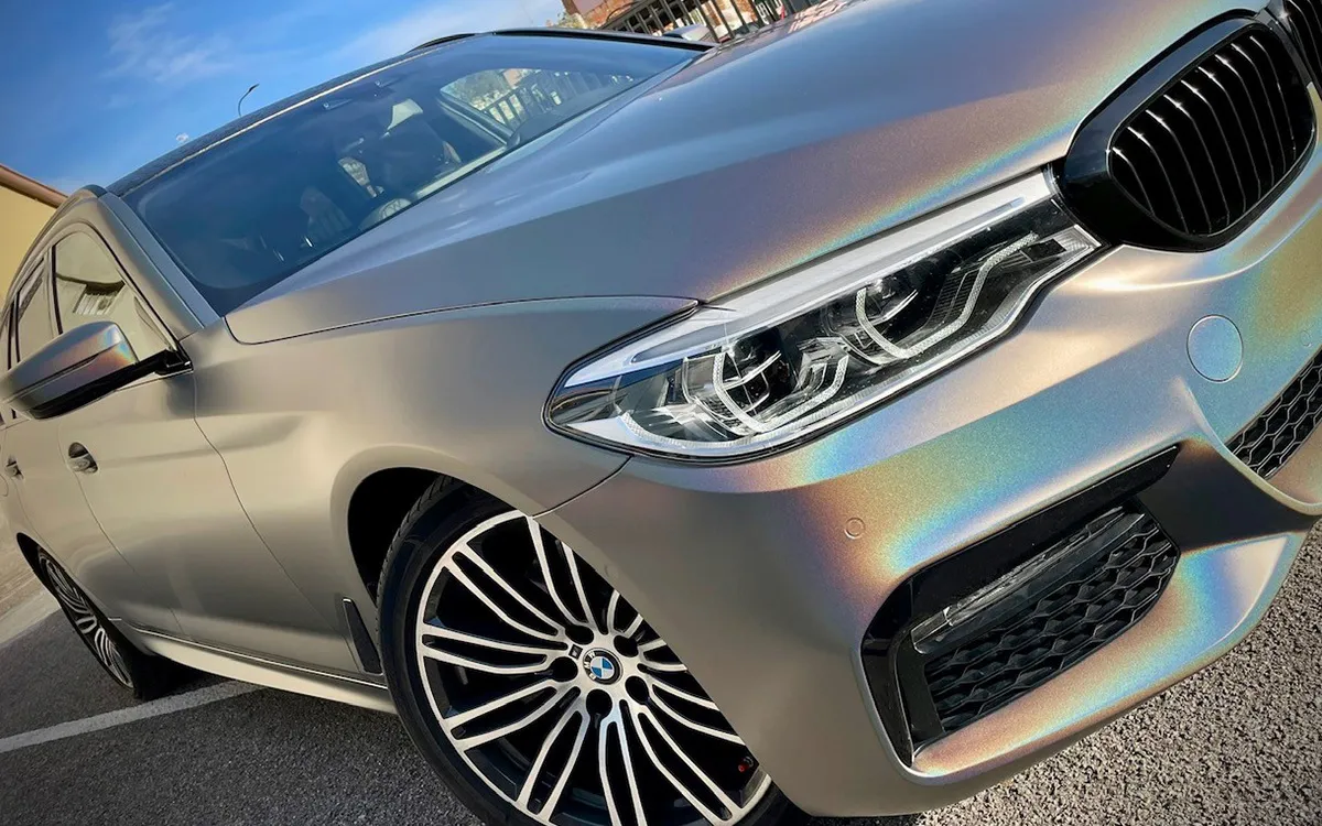 Car wrapping BMW Serie 5 con pellicola cangiante color-shift grigio iridescente.